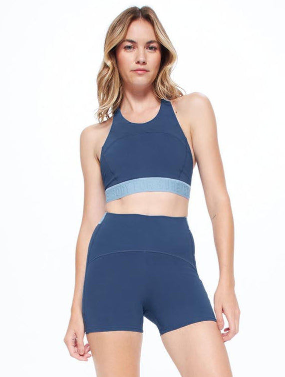 Woman wearing a blue athletic outfit on a white background